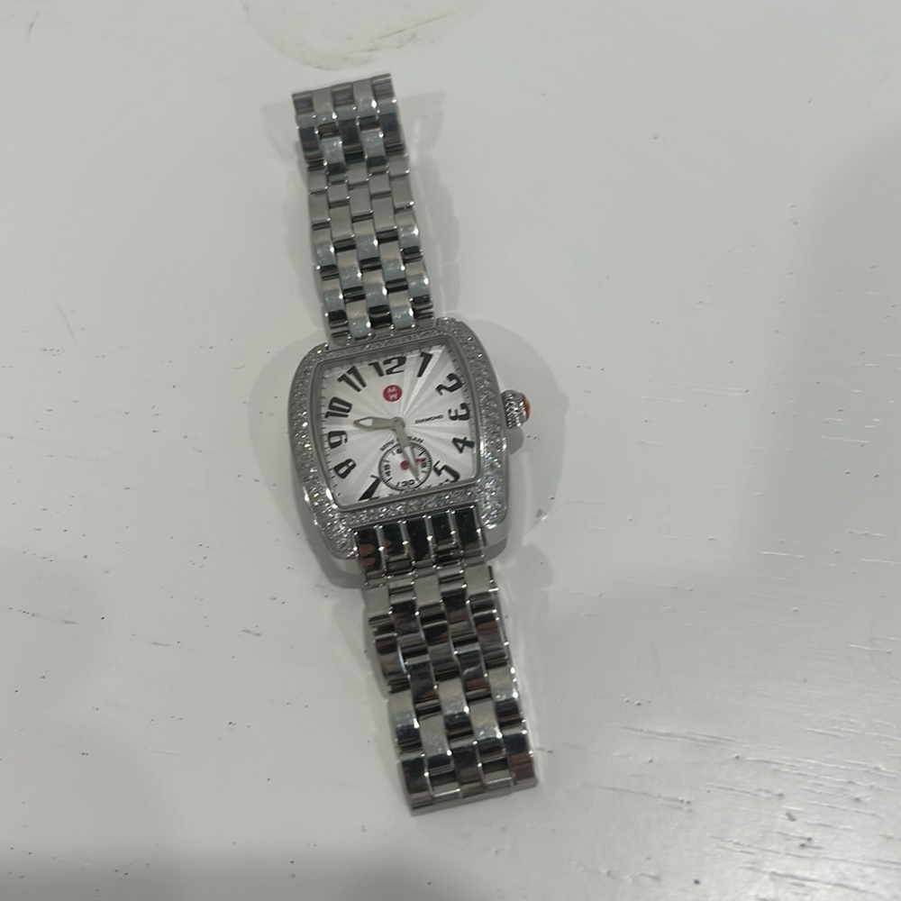 Silver tone Michele watch with bezel surrounded by diamonds. It’s perfect